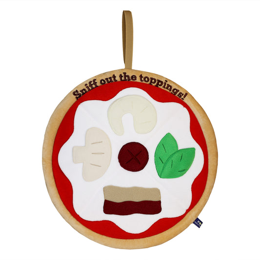 A plush pizza dog toy with various toppings made of fabric, featuring the text "Sniff out the toppings!" along the top edge.