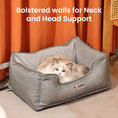 Load image into Gallery viewer, A fluffy white cat resting in an ash-grey heated cat bed by PawsPik against an orange curtain background with text “Head and Neck Support”.