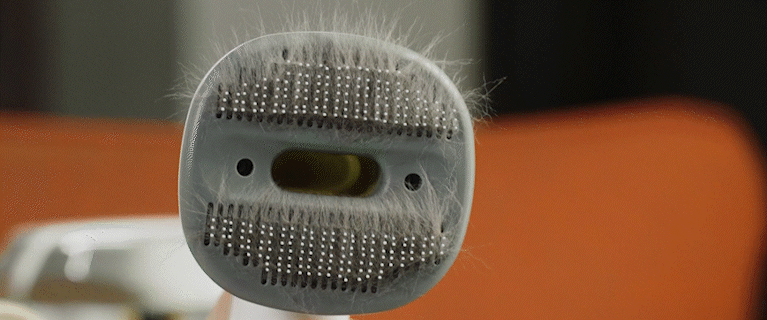 showcasing the simplicity of suctioning the hair from a pet grooming brush