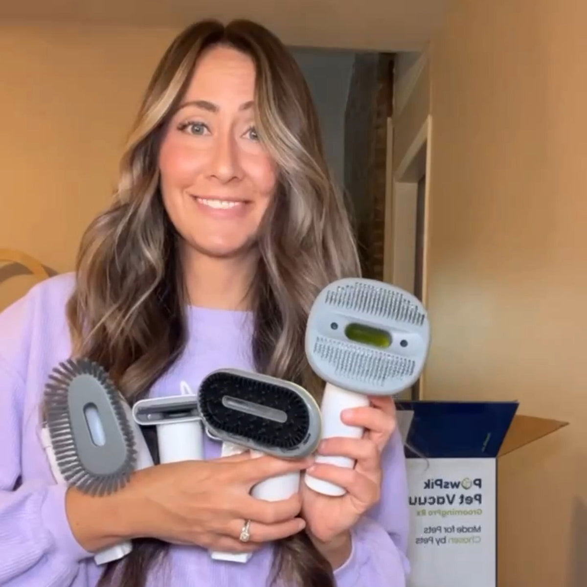 Person holding various dog grooming kit tools by PawsPik.