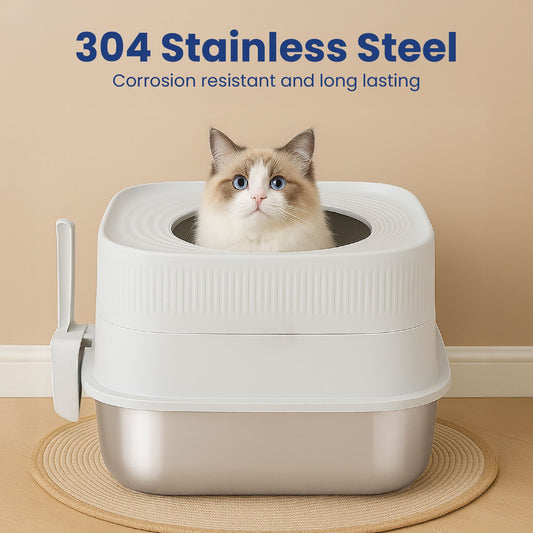 A fluffy cat sits in a modern stainless steel top entry cat litter box with a white, ribbed top and a scooper on the side, against a beige wall.