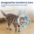 Load image into Gallery viewer, A gray tabby cat wearing a colorful cat cone walks on wooden flooring, with a cozy couch in the background.
